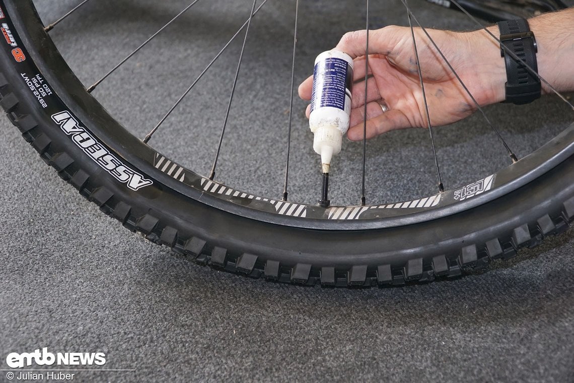 Nachdem der Reifen komplett aufgezogen ist, ist das Befüllen über die Hülse des Tubeless-Ventils unserer Erfahrung nach die sauberste Lösung.