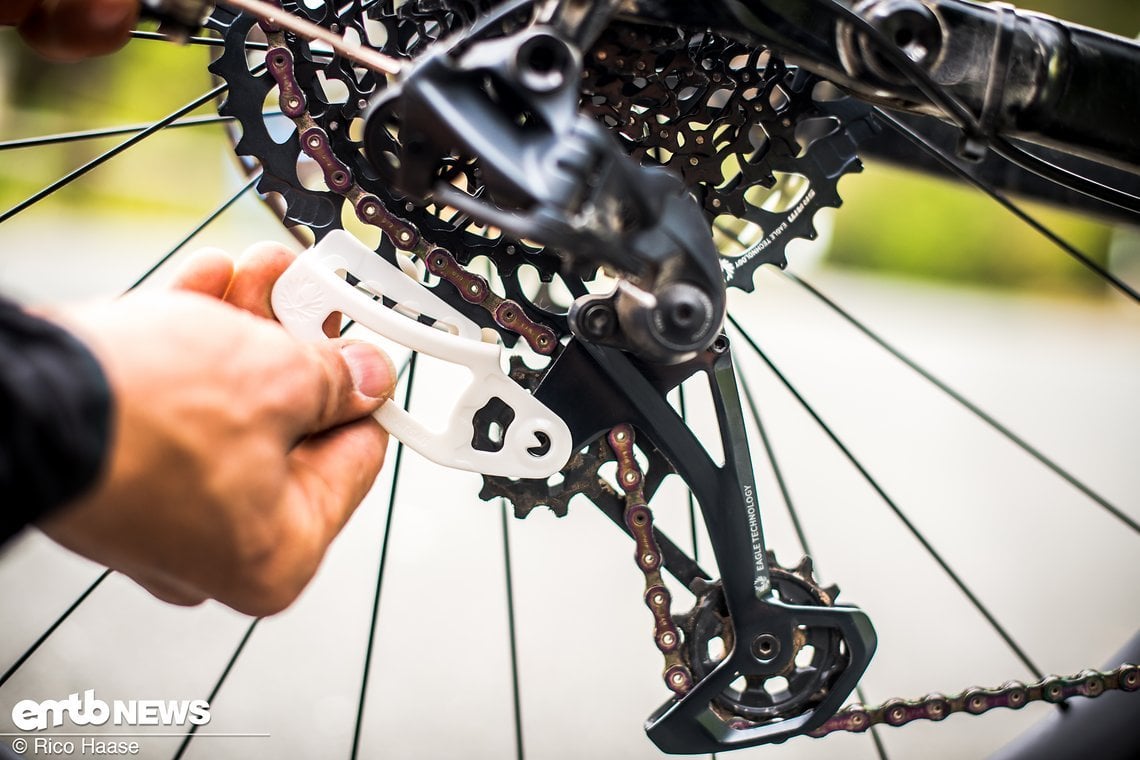 SRAM GX Eagle Chaingap-Tool Anwendung: Kette auf das 42er Ritzel, Tool auf das größte Ritzel (50er oder 52er) klippen (es hält von allein), dann ...