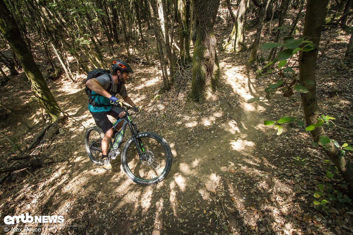Stand up on the pedals and lean the bike over a bit with your body leaning to the outside of the corner.
