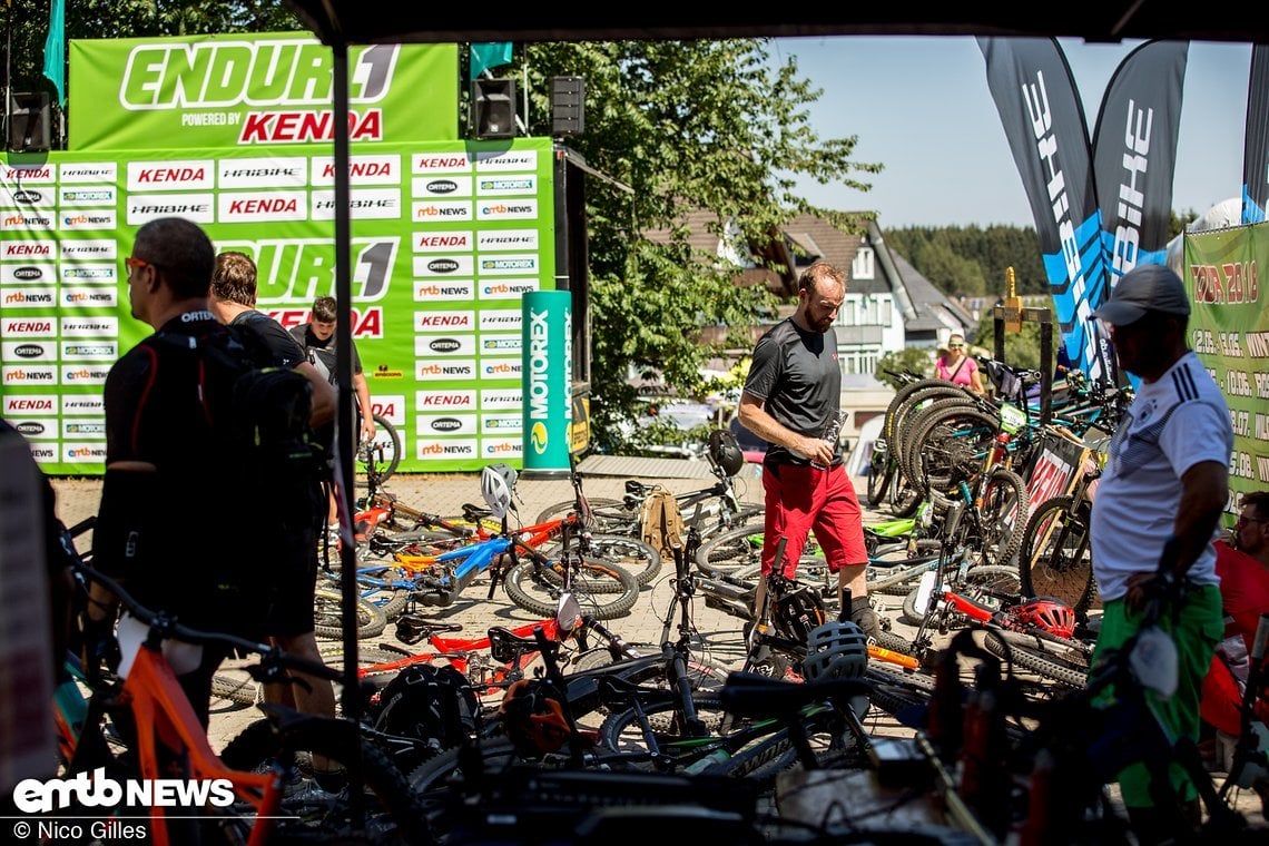 Viele E-Bikes lagen vor dem Start in der Event-Area auf dem Boden, während die Besitzer in der Sonne chillten