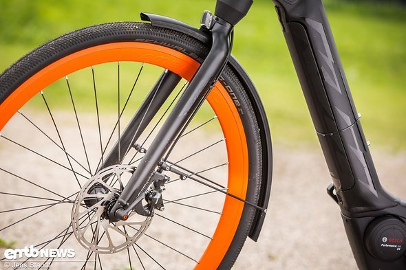 Die Felgen in Knallorange weisen das Rad direkt als KTM aus. Praktisch für Pendler: weit heruntergezogenes Schutzblech Die Felgen in Knallorange weisen das Rad direkt als KTM aus. Praktisch für Pendler: weit heruntergezogenes Schutzblech